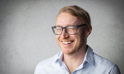 Man smiling with eyes closed and glasses